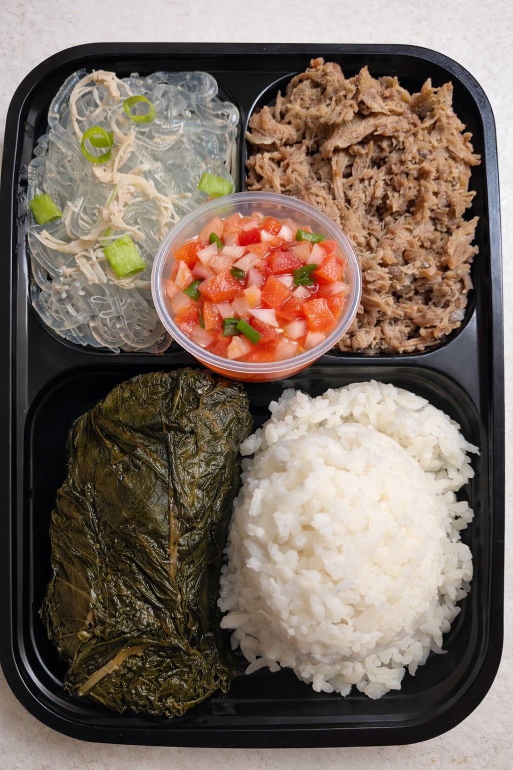 Luau bento with kalua pig, laulau, chicken long rice, lomi tomato, and rice